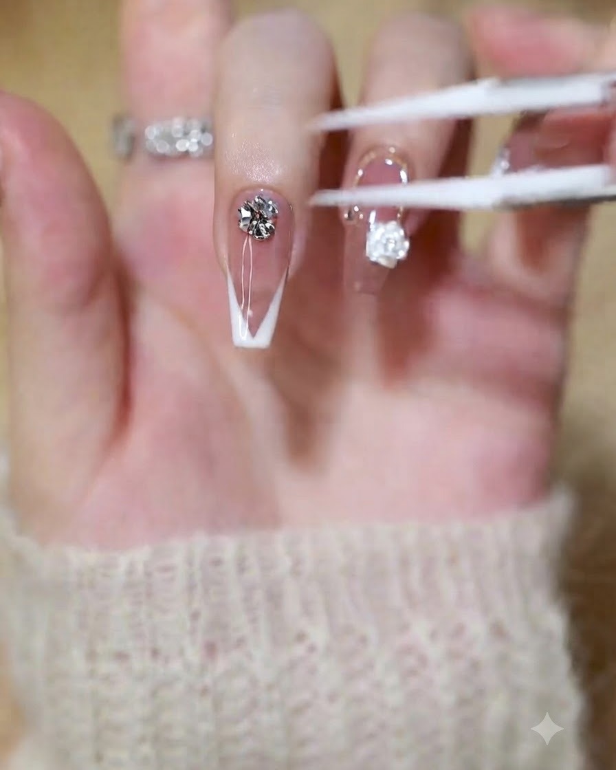 Un pincel o herramienta aplicando gel de construcción transparente en la punta de una uña con manicura francesa.