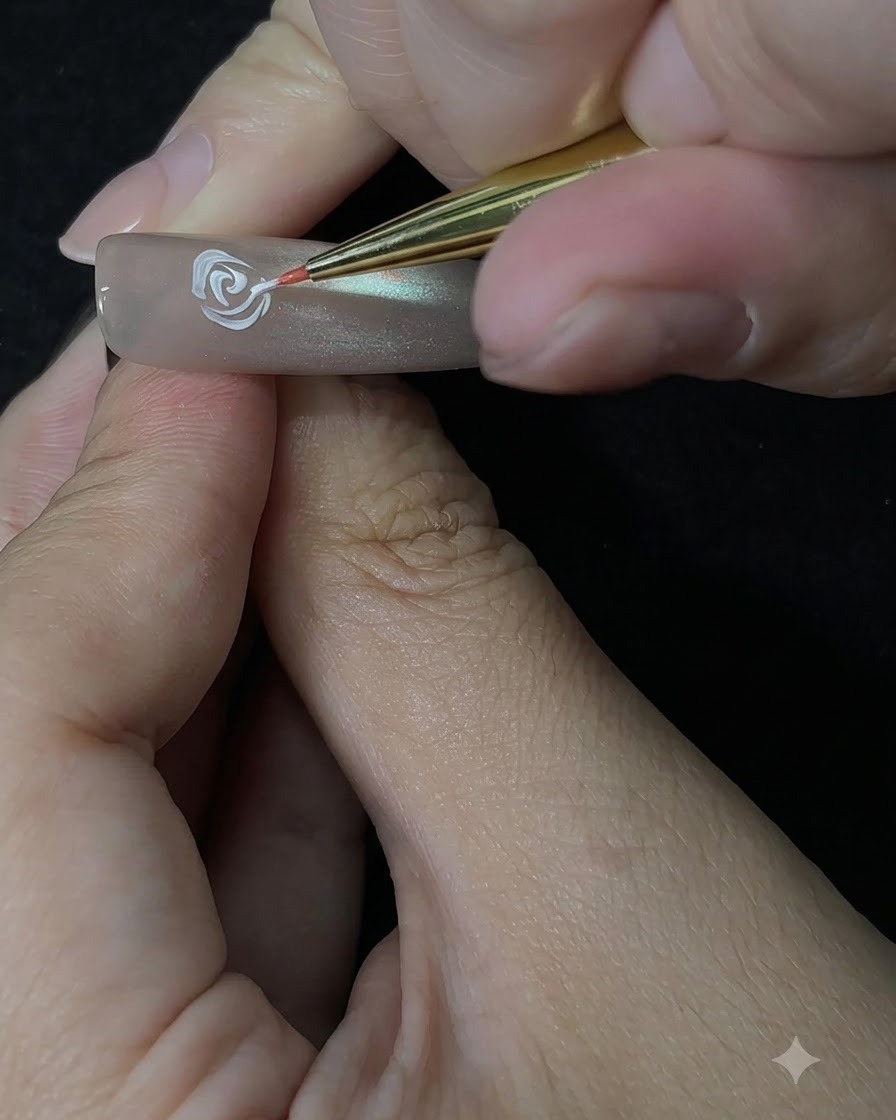 Un pincel de detalle construyendo los pétalos exteriores de la rosa usando un movimiento de punteado en la uña.