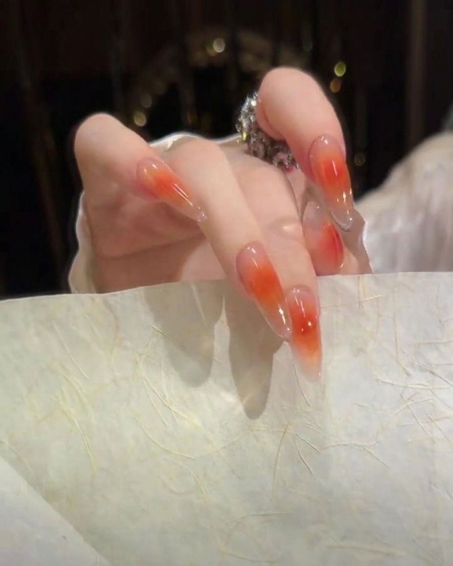 Una vista de perfil lateral de uñas de gel esculpidas que muestran una superficie lisa de alto brillo y un perfil de arco limpio.