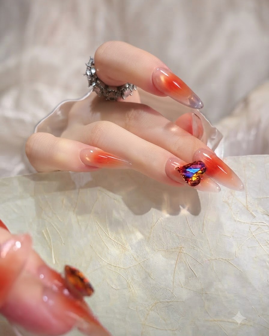 Una imagen en primer plano de un pulgar que muestra una uña larga en forma de almendra con un degradado de gel jelly naranja uniforme y translúcido.