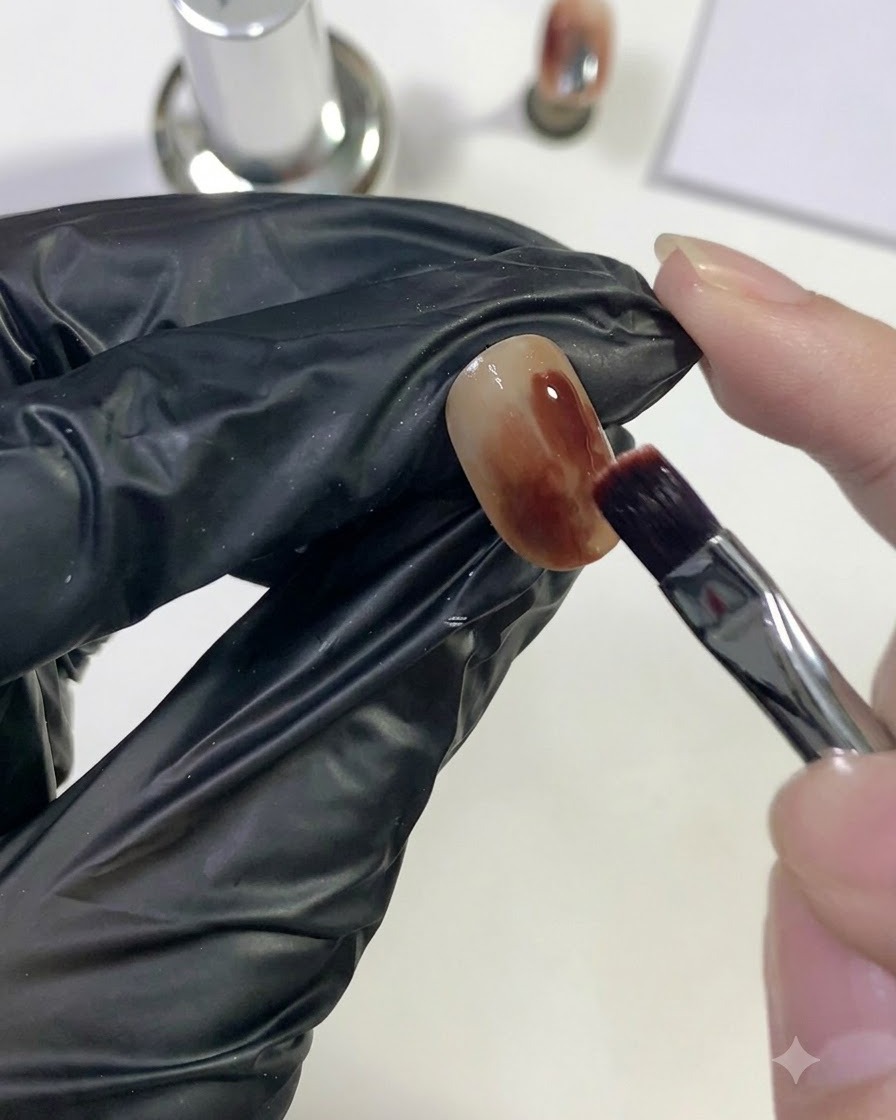 Un pincel aplicando gel rojo intenso sobre un área localizada de la uña.