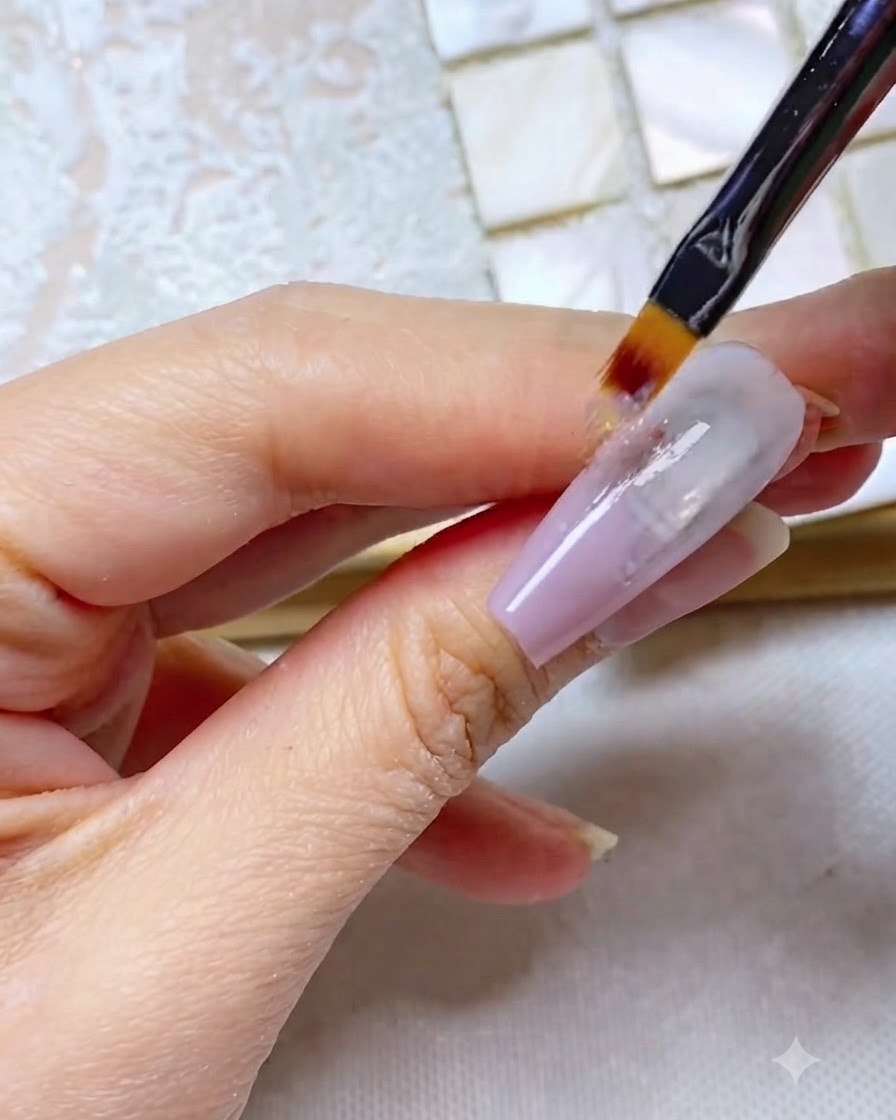 Un pincel ombré arrastrando gel gris morado hacia abajo a lo largo de la uña, creando una apariencia con rayas.
