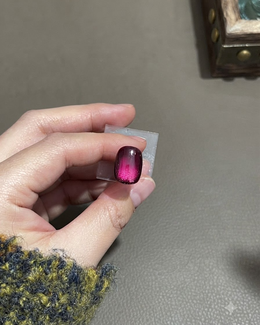 Una uña cat-eye degradada en mate terminada que muestra una textura de terciopelo escarchado con un brillo concentrado en la parte media inferior.