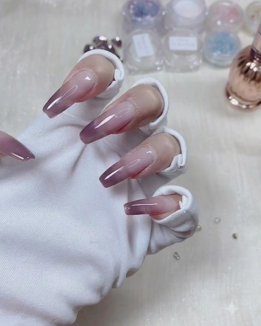 Una mano con guantes girada hacia abajo para permitir que el gel transparente se autonivele y forme un arco estructural suave.