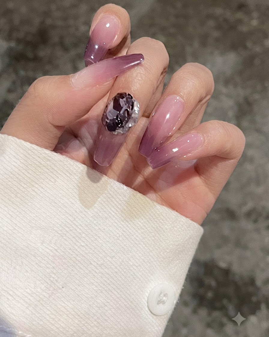 Un primer plano de un dedo con una uña con degradado morado que muestra una gema en forma de corazón colocada para comparar.