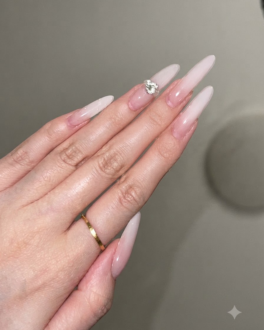 Una gota de adhesivo en gel transparente colocada en el centro de una uña stiletto decorada.