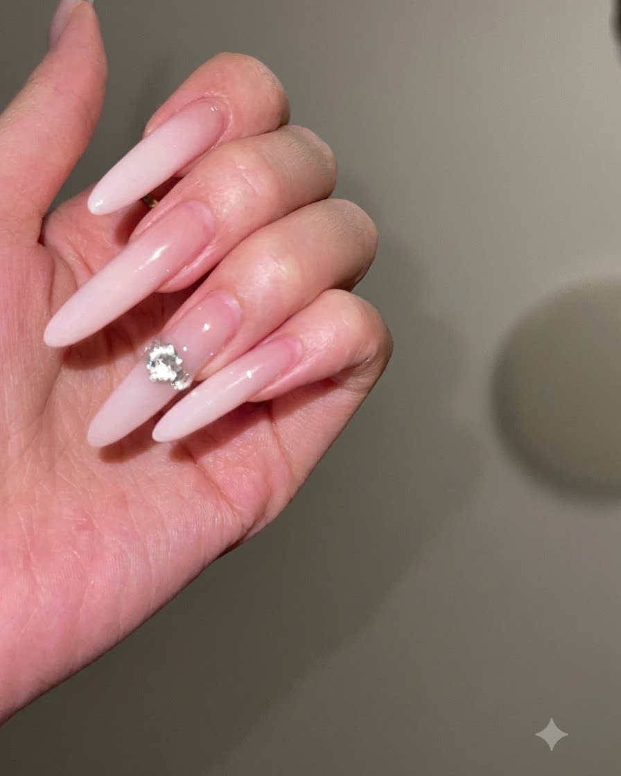 Una lima de uñas dando forma y afinando los bordes laterales de una uña larga tipo stiletto.