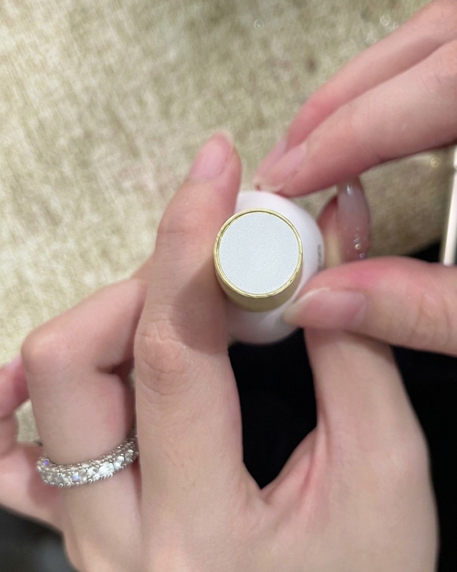 Una botella de top coat transparente sostenida en la mano, lista para sellar el diseño final de las uñas.