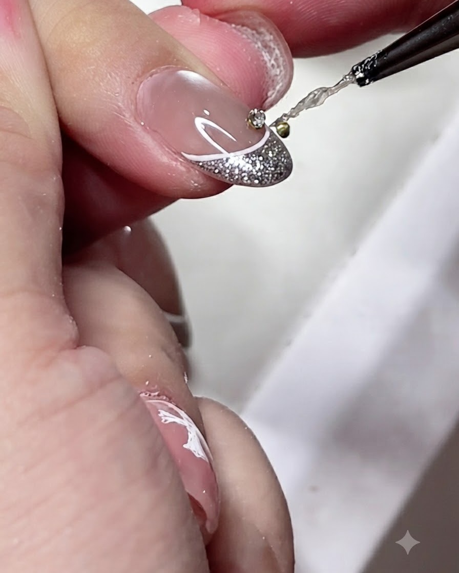 Un pincel de detalles aplicando una pequeña gota de adhesivo de gel transparente en el centro de una punta de manicura francesa decorada.
