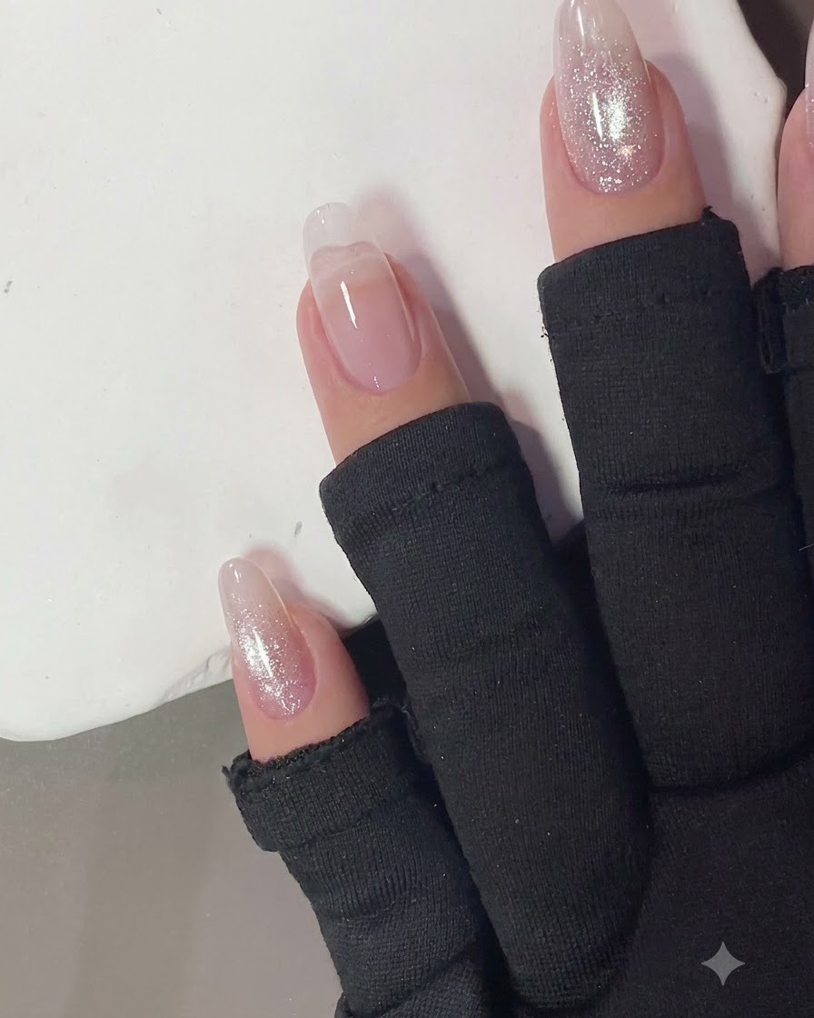 Uñas curándose bajo la luz de una lámpara UV o LED compacta.