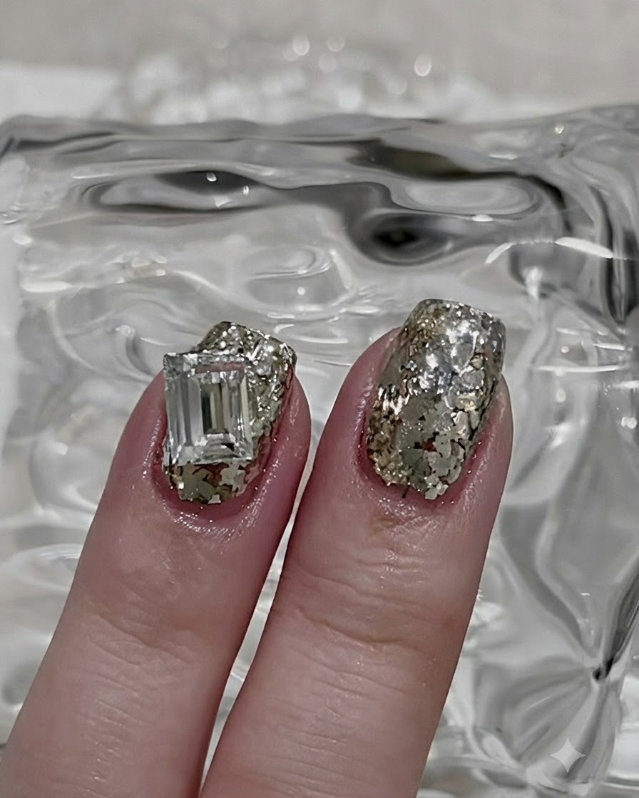 Un pincel fino de nail art tomando una pequeña porción de polvo de purpurina plateada suelto.