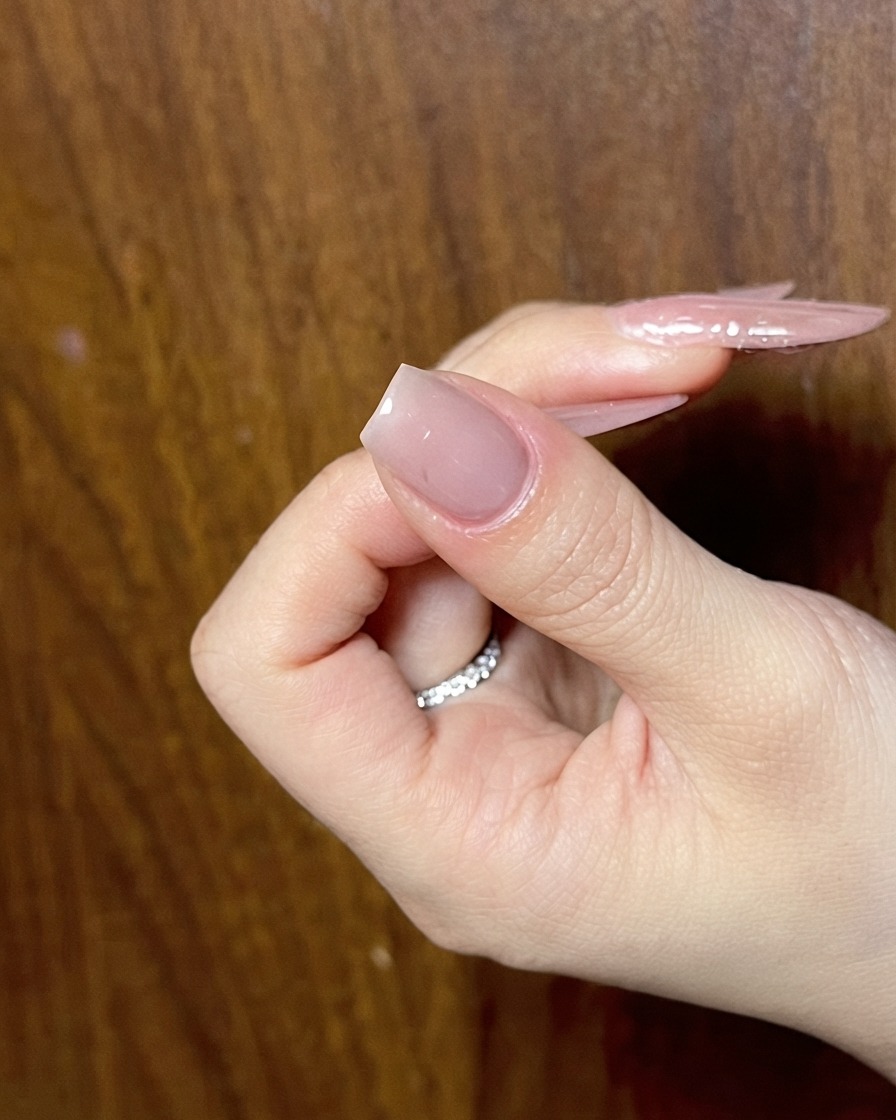 Una mano que muestra una uña nude preparada lista para la siguiente fase de arte de uñas detallado.