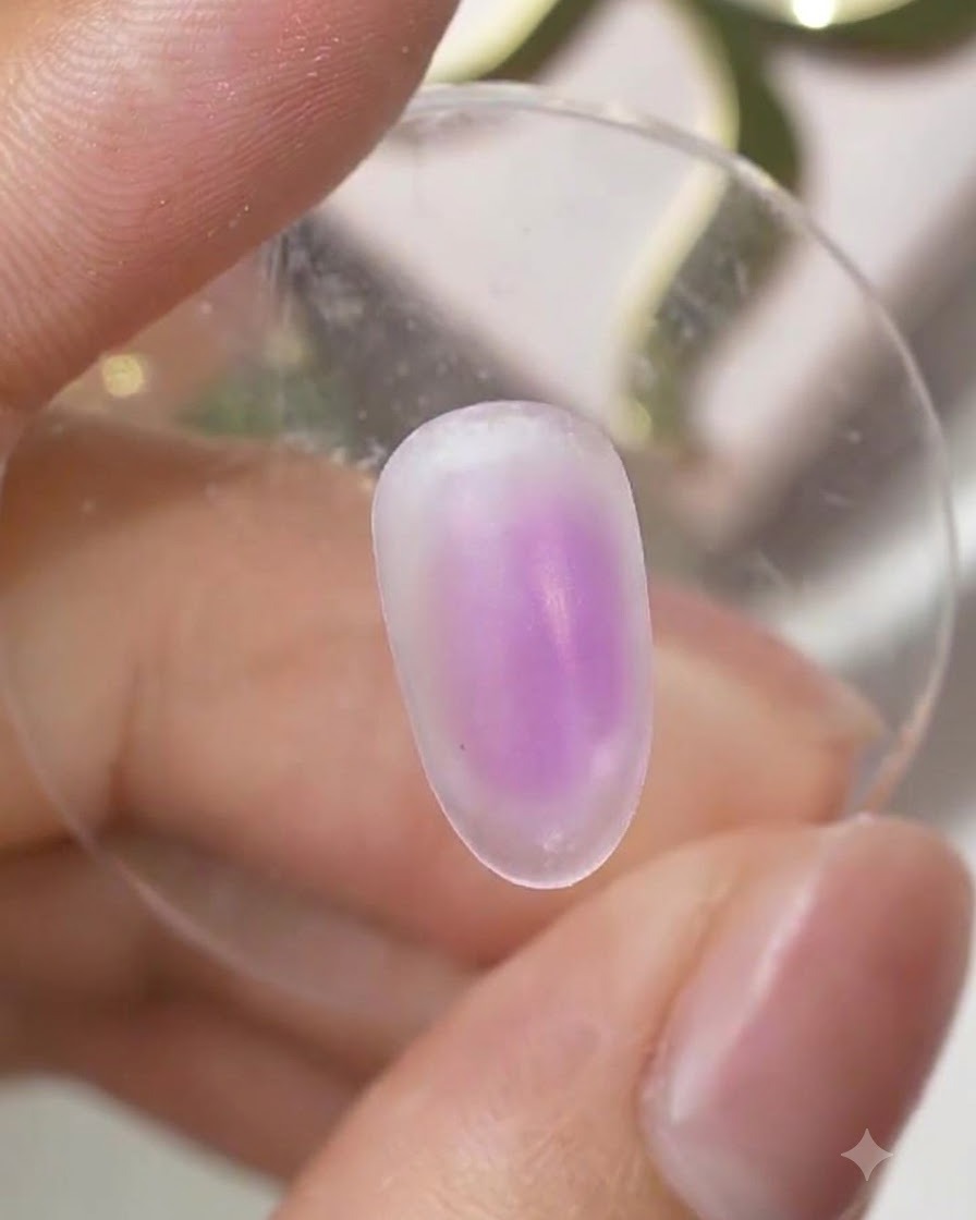 Superficie de una uña curada que muestra un suave degradado ombré de tono morado centrado en la uña.