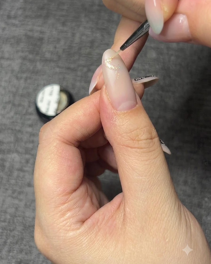 Primer plano de una uña con el contorno de mariposa hecho en gel brillante.