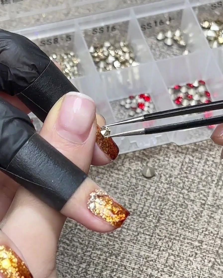 Una mano posicionada para sostener un dedo boca abajo para la nivelación del gel durante un tutorial de uñas.