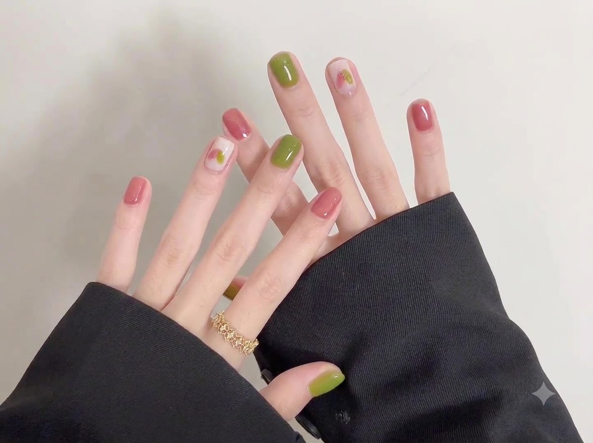 Una toma de cerca que destaca el intrincado arte doodle creado sobre una capa base suave y clara en uñas cortas.