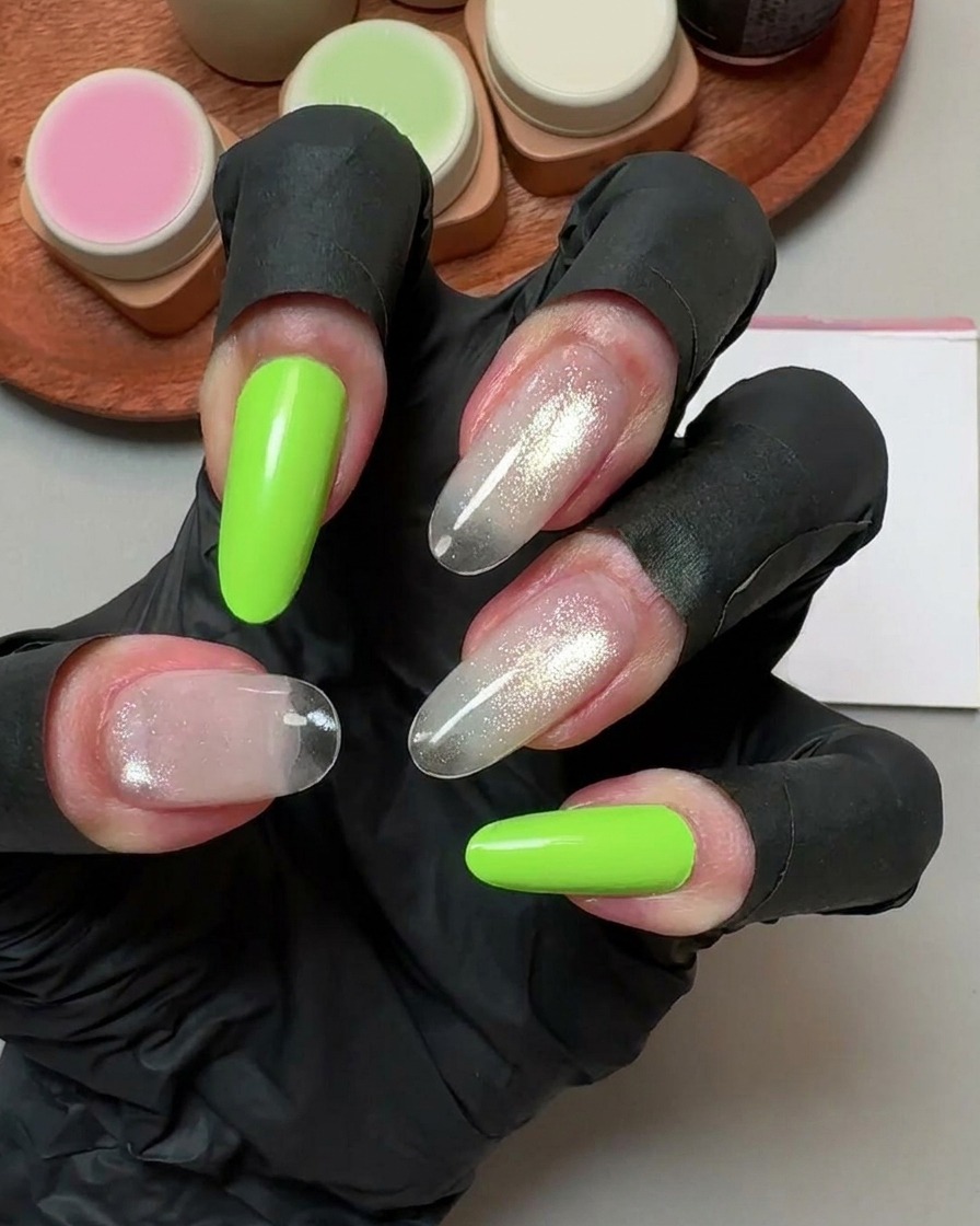 Una mano con guantes negros sosteniendo una almohadilla de limpieza sobre uñas postizas curadas.