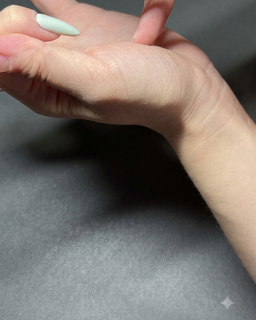 Un pincel fino aplicando esmalte de gel verde menta claro en una uña.