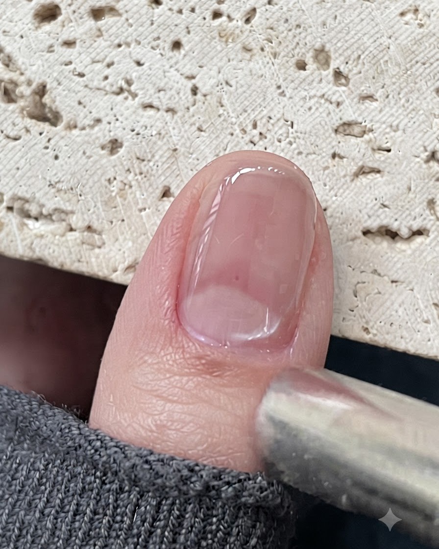 Una herramienta de imán posicionada cerca de una uña de gel cat eye brillante para atraer las partículas magnéticas.
