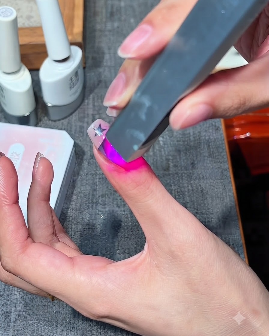 Una mini lámpara UV/LED portátil para uñas curando un diseño de gel en un dedo.