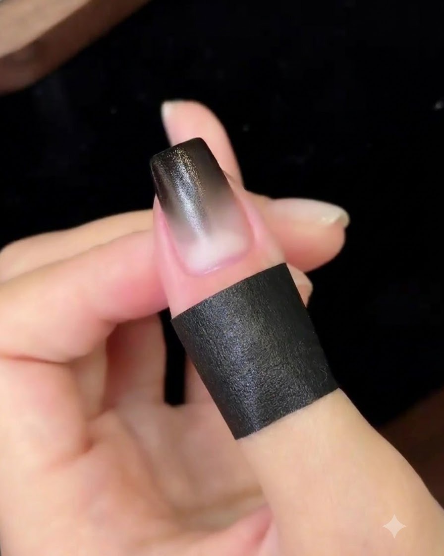 Una uña con degradado terminada curando bajo una lámpara UV/LED compacta para uñas.