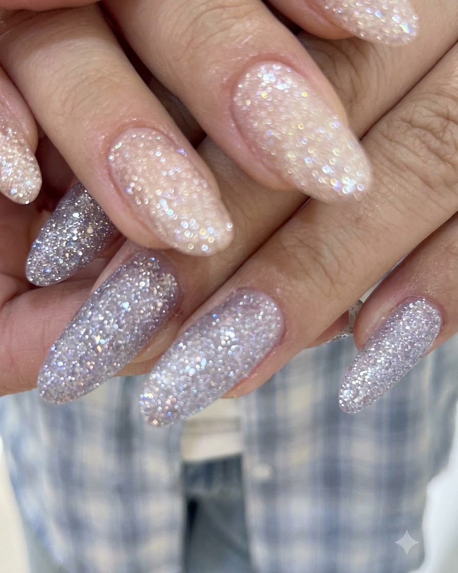 Un primer plano detallado que muestra el brillo de cristal translúcido y la cobertura suave de gel con glitter en uñas largas.