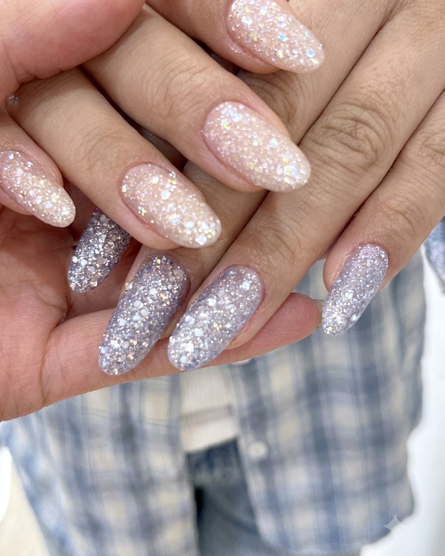 Una vista macro nítida que resalta las finas partículas brillantes en las uñas de gel con glitter lavanda y morado.