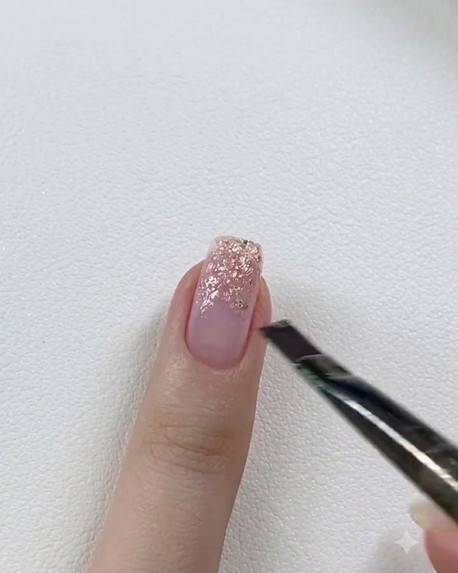 Una pequeña linterna mini UV/LED curando el gel de purpurina aplicado en una uña sobre una mesa blanca.