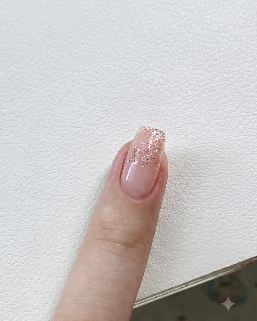 Unas pinzas colocando una pegatina de estrella pequeña en una uña con degradado de purpurina.