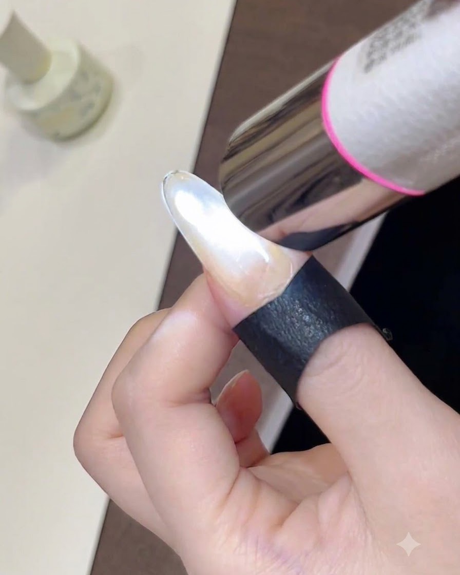 Primer plano de una mini lámpara UV curando el esmalte en gel ojo de gato recién moldeado en una uña.