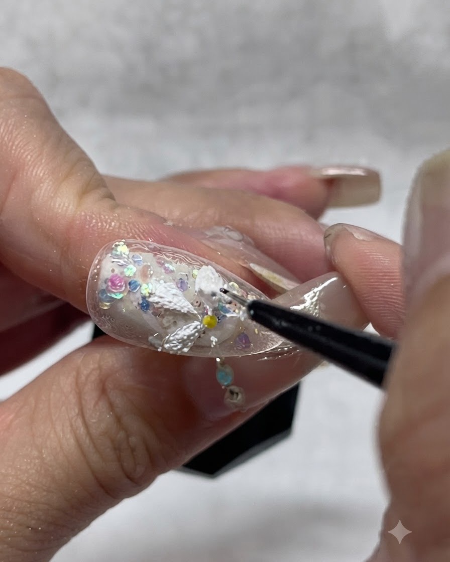 Un artista de uñas agregando gel texturizado blanco adicional sobre los pétalos de margarita pintados para mejorar la profundidad y opacidad en 3D.