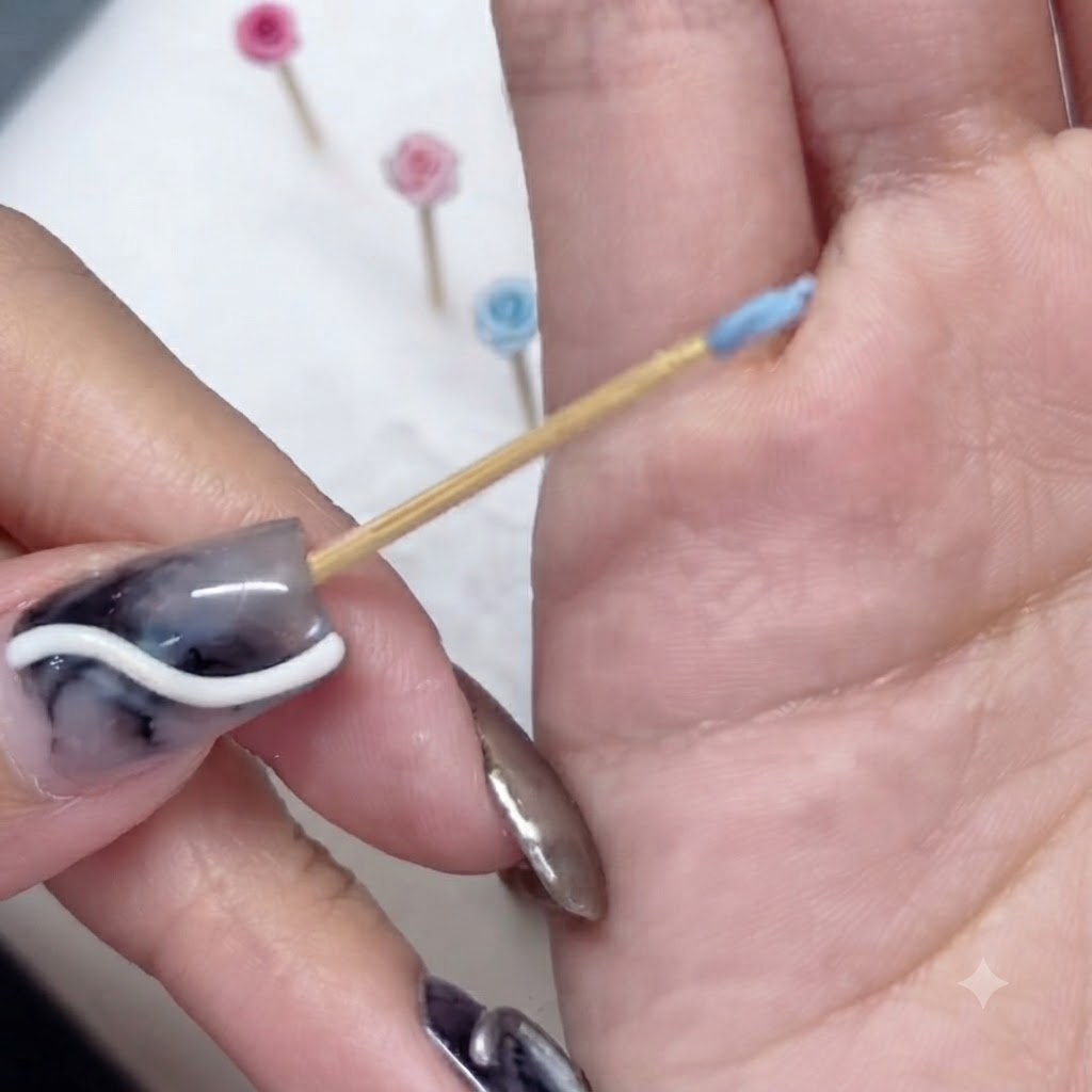 Un primer plano de un diminuto pétalo azul esculpido envuelto alrededor de la punta de un palillo de madera.