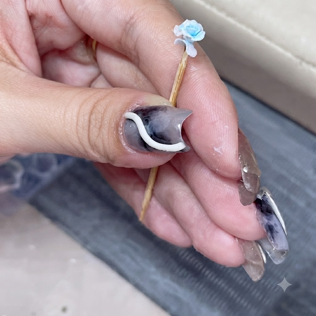 Un primer plano de una rosa azul en miniatura en un palillo con un pétalo superpuesto recién añadido.