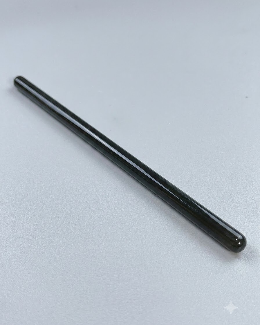 Un pincel largo de punta fina para nail art descansando sobre una superficie limpia antes del trabajo de líneas detallado.