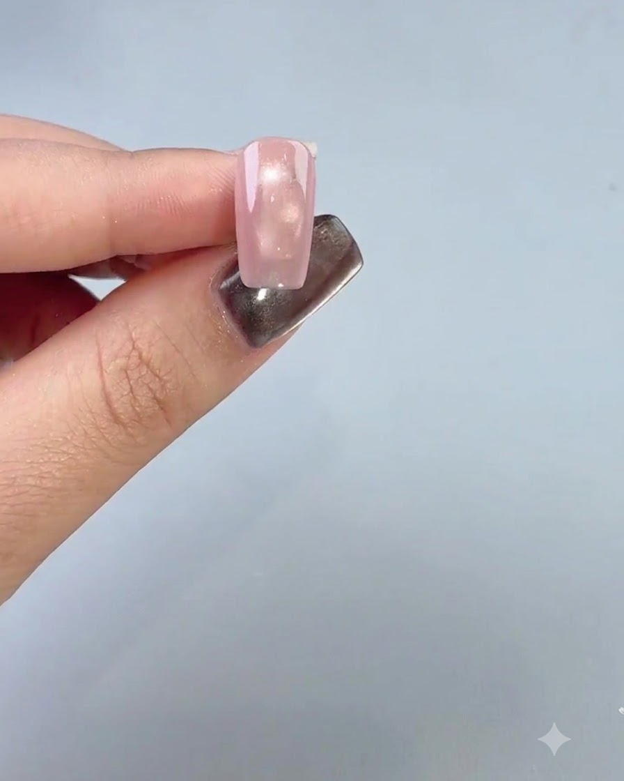 Un dedo con manicura que muestra una capa base suave aplicada a la cuarta uña.