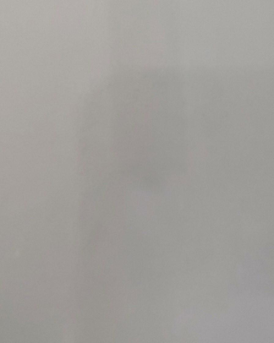 Una mano colocando una uña dentro de una lámpara de curado de uñas UV/LED brillante.