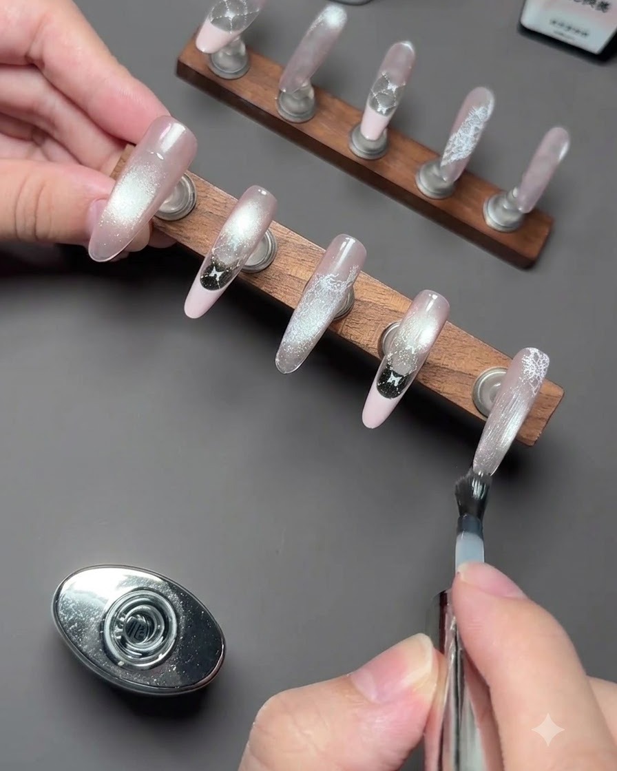 Un par de pinzas de precisión recogiendo un pequeño dije 3D de gatito blanco.