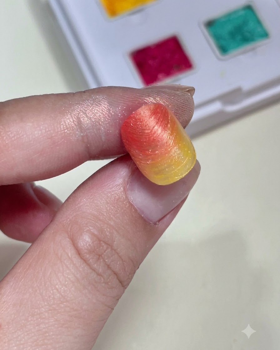 Un primer plano sosteniendo un tip de uña con degradado texturizado que muestra la forma y el color del fondo antes de agregar los dijes.