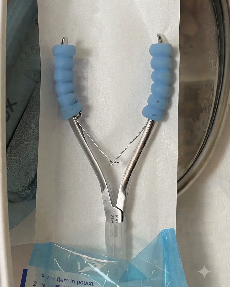 Un par de alicates de metal esterilizados para cutículas dentro de una bolsa de embalaje abierta.