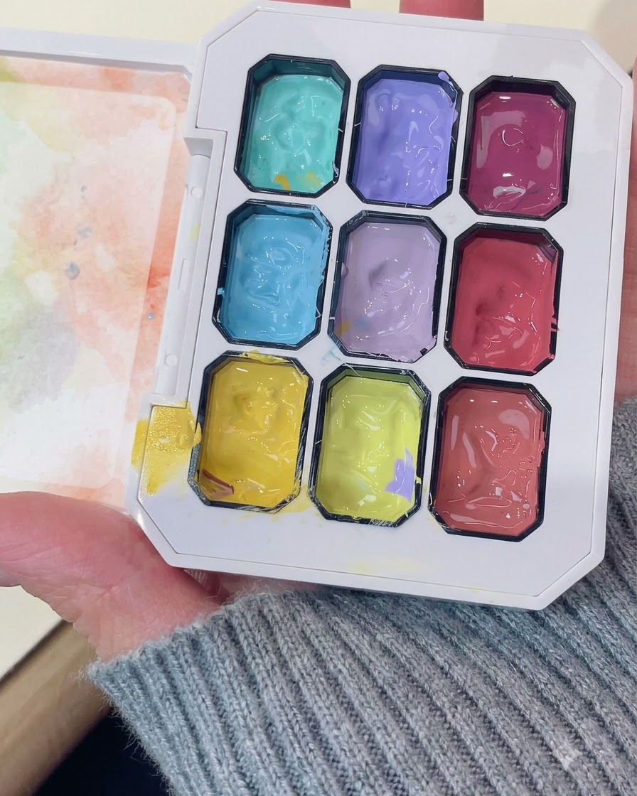 Una paleta de gel profesional que muestra compartimentos con gel morado vibrante y otros colores.