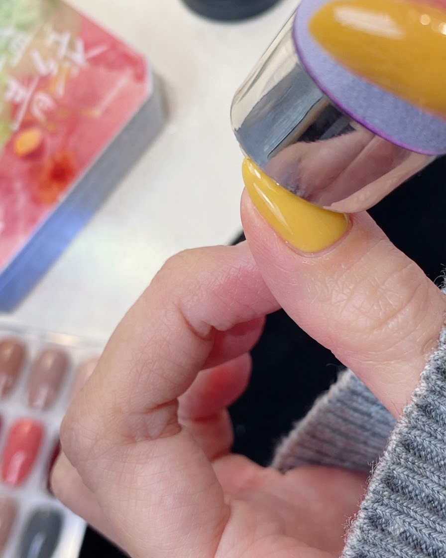 Un dedo arreglado colocado bajo una lámpara de uñas UV o LED para su secado.