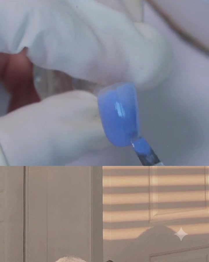 Un pincel de gel plano aplicando una capa de gel azul-púrpura sobre la superficie de una uña.