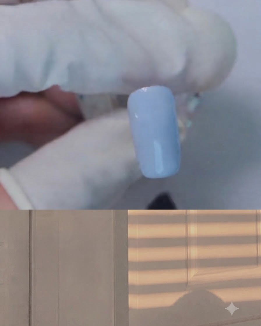 Un pincel aplicando gel blooming transparente sobre una uña azul claro.