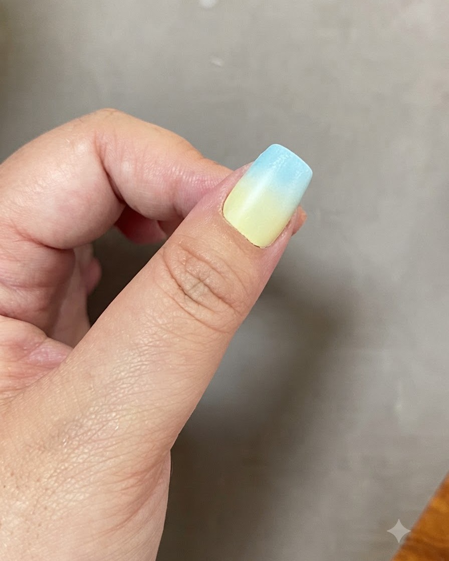 Una uña con un degradado azul y amarillo curándose dentro de una lámpara de uñas UV LED.