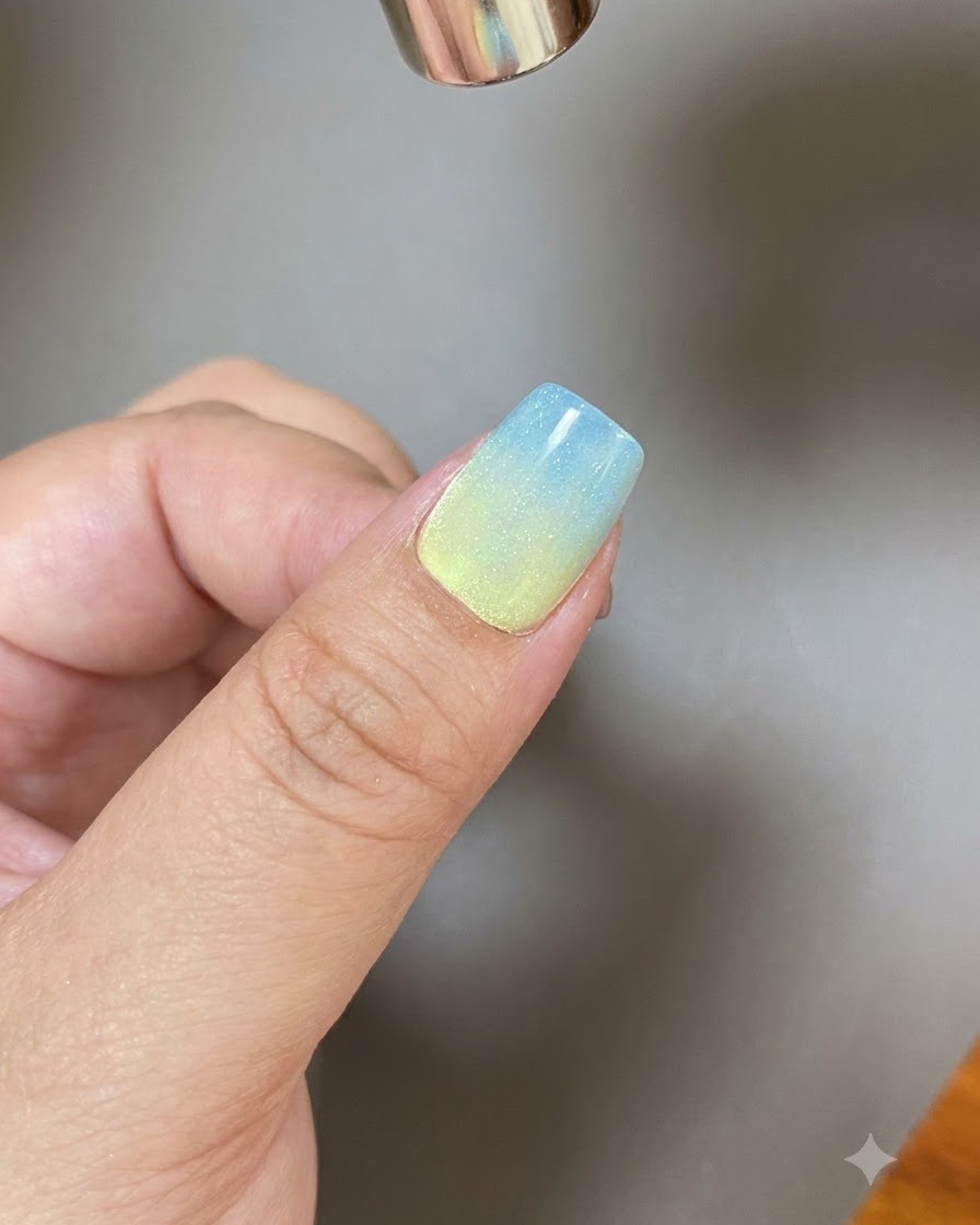 Una herramienta magnética dando forma a una amplia franja de luz a través de una uña con recubrimiento de gel brillante.