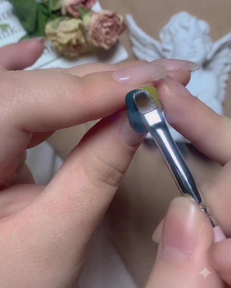 Un pincel deslizándose horizontalmente por la línea divisoria central entre el gel verde y azul.