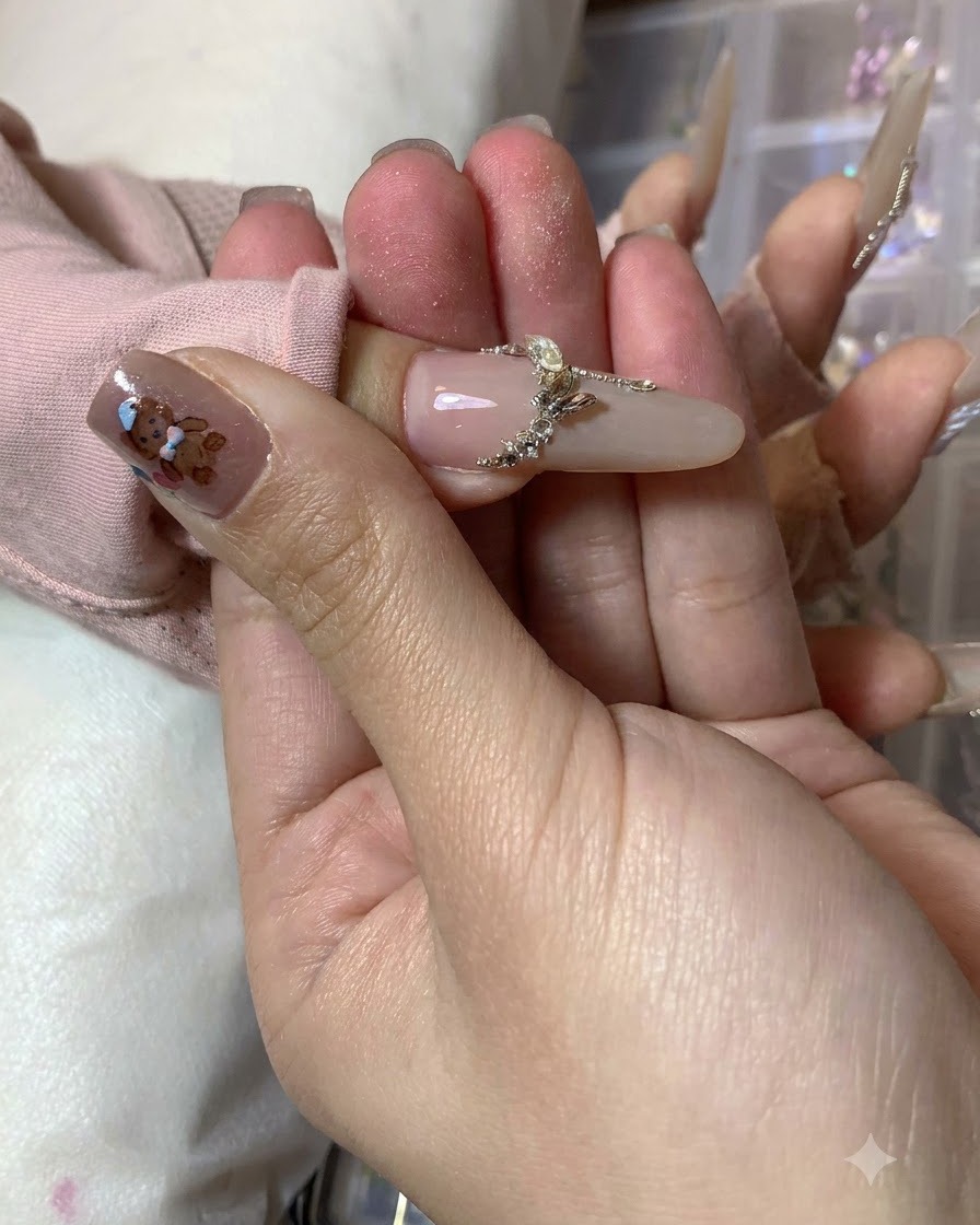 Una artista de uñas agregando trazos de acento blancos finales a lo largo de los bordes exteriores del nail art de mariposa completado.