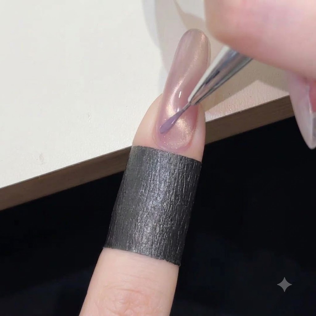 Un pincel delineador fino pintando una delicada línea ondulada de esmalte en gel morado sobre la base brillante de ojo de gato rosa.
