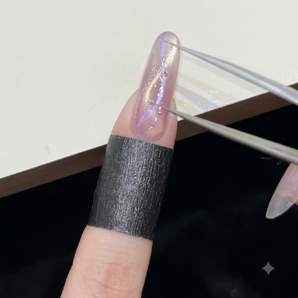 Pinzas de precisión colocando diminutas lentejuelas plateadas en forma de estrella sobre una superficie de uña de gel húmedo.