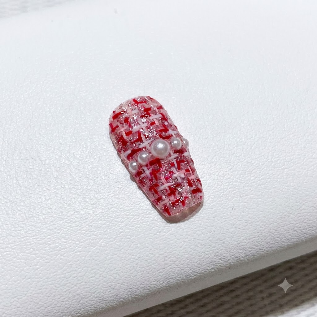 Un pincel fino rellenando esmalte en gel rojo vibrante en un lado de una punta de manicura francesa en forma de V.